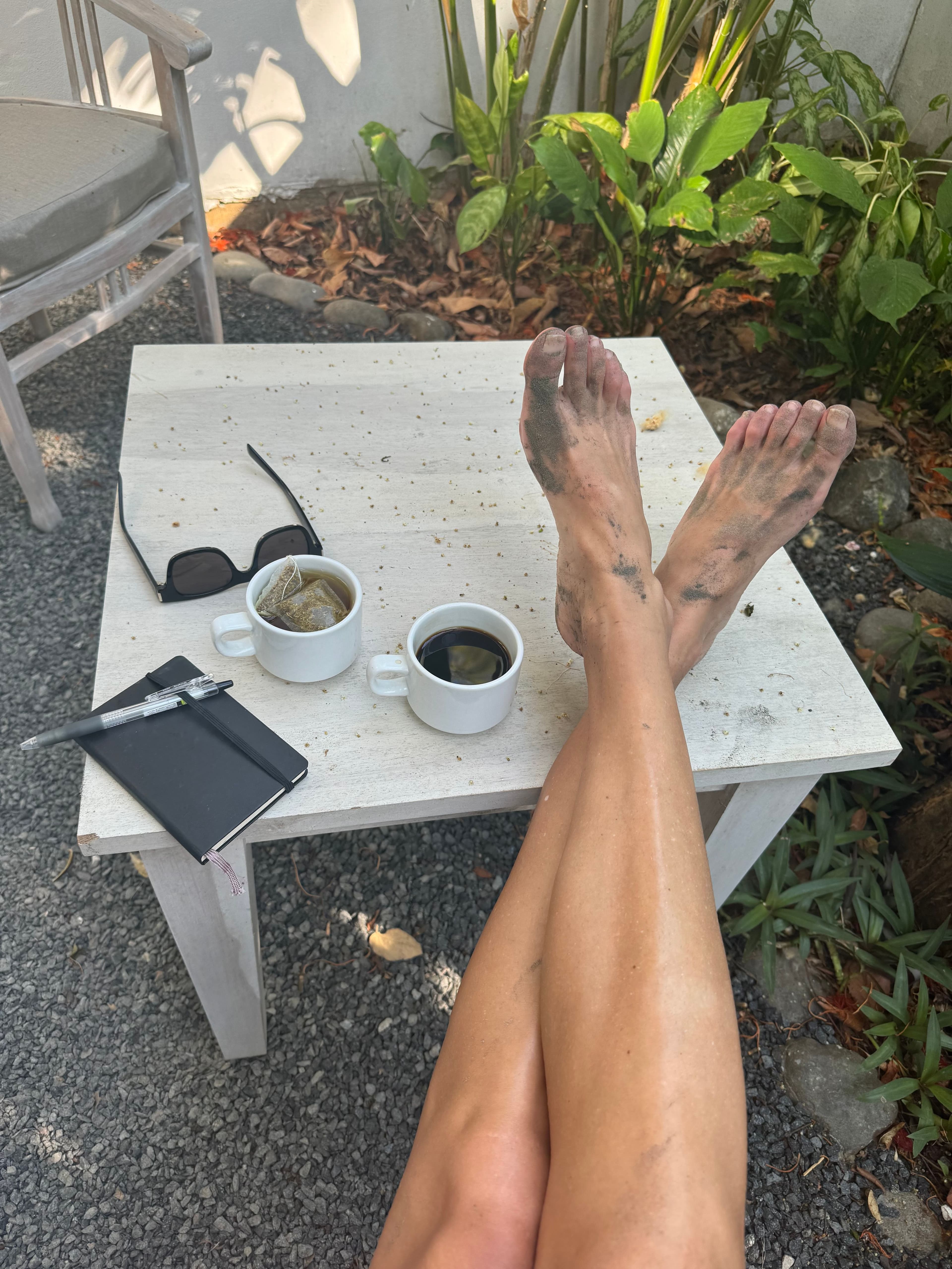 Rachelle Robinett's feet on a table with tea and a notebook next to them