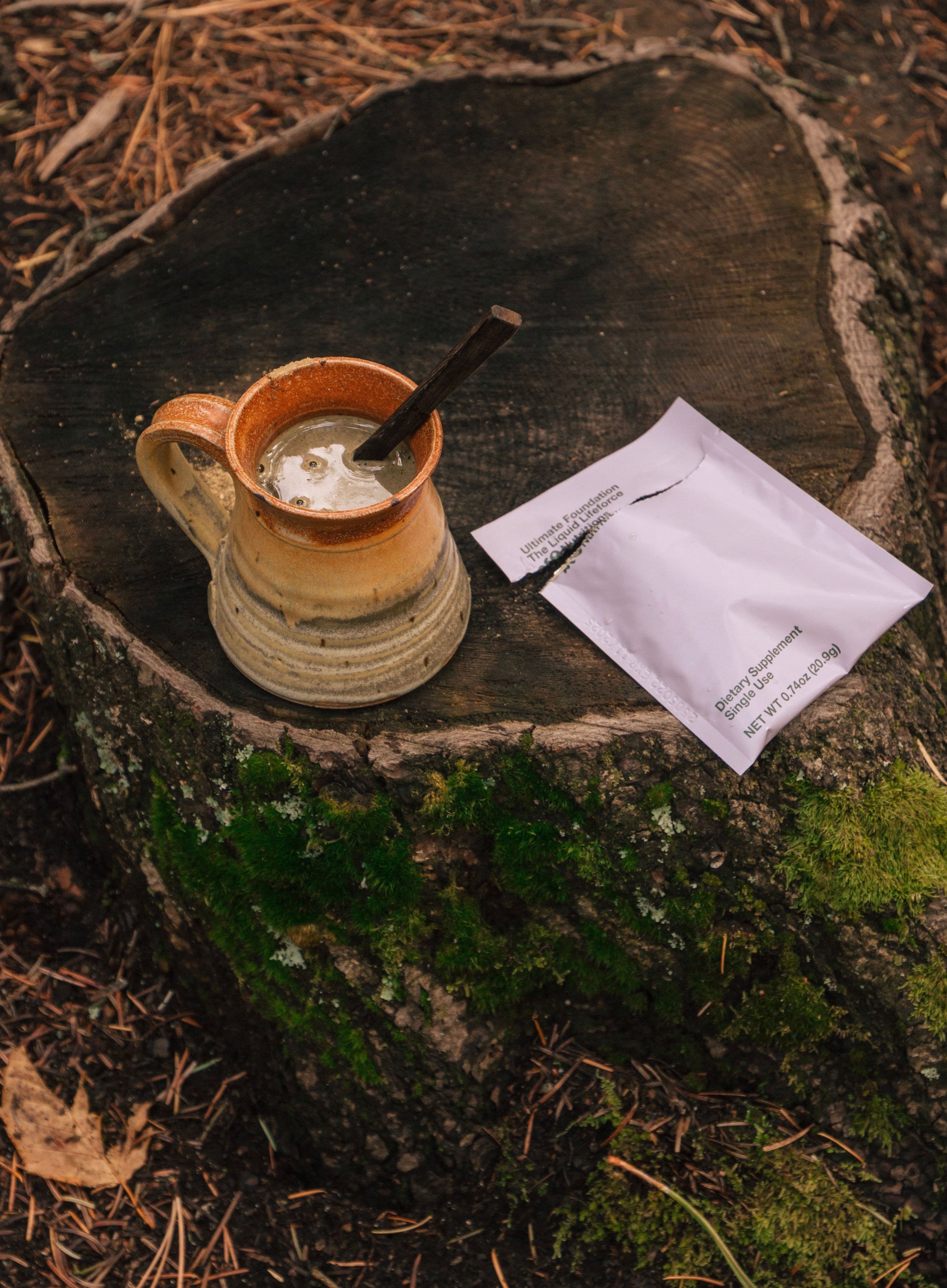 a cup with brewed neoNutritions Ultimate Foundation on a tree stump